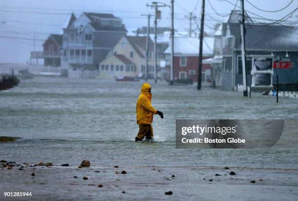 Man walks through a flooded section of Brant Rock in Marshfield, Mass., on Jan. 4 as the afternoon high tide struck during the blizzard.