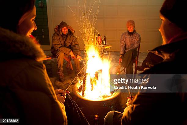 group of friends enjoying winter bonfire. - whitefish montana stockfoto's en -beelden