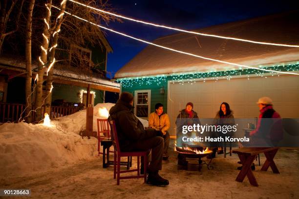 group of friends enjoying winter bonfire. - woman snow outside night stockfoto's en -beelden