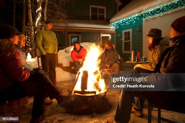 group of friends enjoying winter bonfire. - winter fire fotografías e imágenes de stock