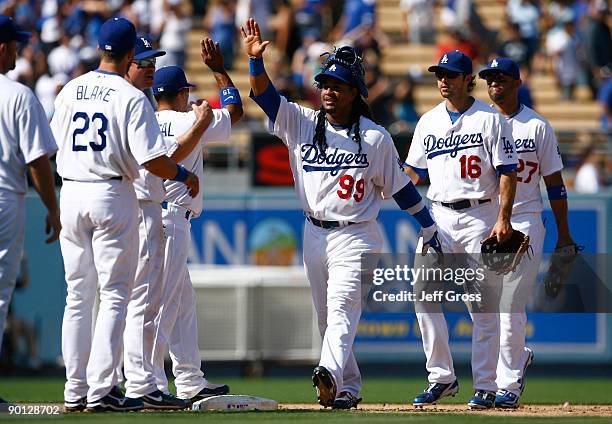 Manny Ramirez of the Los Angeles Dodgers receives high fives from his teammates following their victory over the Chicago Cubs at Dodger Stadium on...