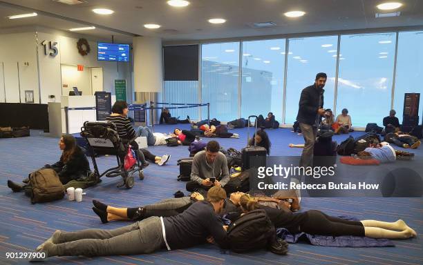 Passengers wait for their delayed flights at gate 15 in terminal five at John F. Kennedy International Airport on January 4, 2018 in the Queens...