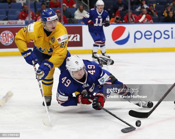 Max Jones of United States tries to control the puck as Jacob Moverare of Sweden defends in the second period during the IIHF World Junior...