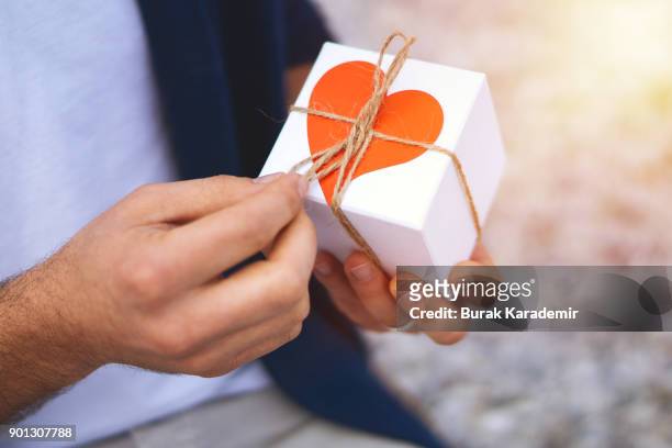valentine's day - guy isolated holding a small box in his hand imagens e fotografias de stock