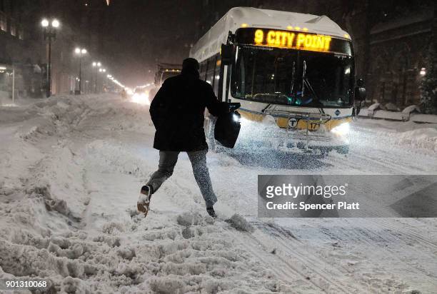 Man walks through the streets of Boston as snow falls from a massive winter storm on January 4, 2018 in Boston, United States. Schools and businesses...