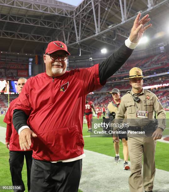 Head coach Bruce Arians of the Arizona Cardinals waves to fans as he walks off the field following the NFL game against the New York Giants at the...