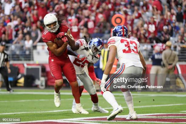 Wide receiver Larry Fitzgerald of the Arizona Cardinals scores on a 13 yard touchdown reception against defensive back Brandon Dixon and cornerback...