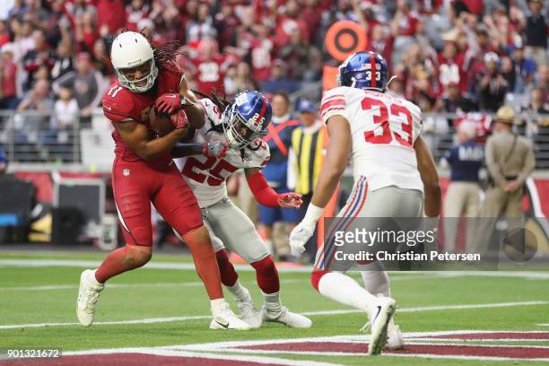 Wide receiver Larry Fitzgerald of the Arizona Cardinals scores on a 13 yard touchdown reception against defensive back Brandon Dixon and cornerback...