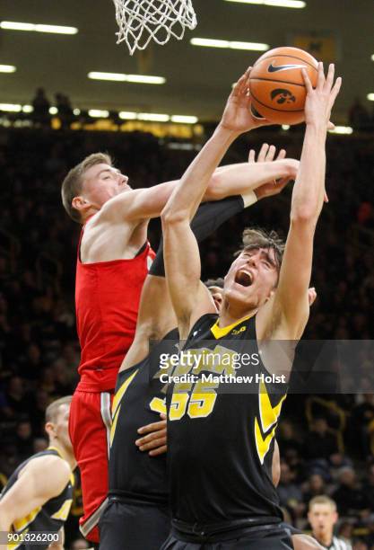 Forward Luka Garza of the Iowa Hawkeyes grabs a rebound during the first half in front of center Micah Potter of the Ohio State Buckeyes on January...
