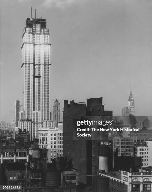 Empire State Building under construction, with view of Chrysler Building in background, New York, New York, 1930.