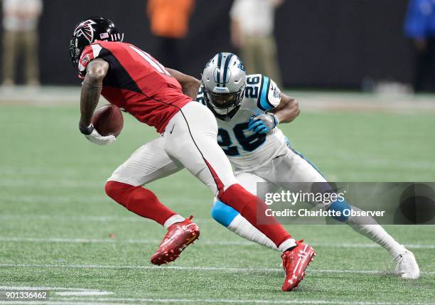 Atlanta Falcons wide receiver Julio Jones strides by Carolina Panthers cornerback Daryl Worley after making a reception at Mercedes-Benz Stadium in...