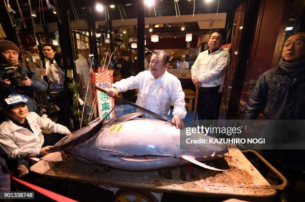 President of sushi restaurant chain Sushi-Zanmai, Kiyoshi Kimura, displays a 190-kilogram bluefin tuna at his main restaurant near Tokyo's Tsukiji...