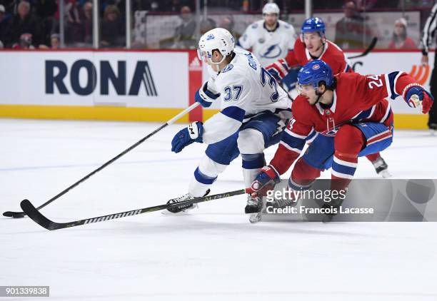 Yanni Gourde of the Tampa Bay Lightning controls the puck against Phillip Danault of the Montreal Canadiens in the NHL game at the Bell Centre on...
