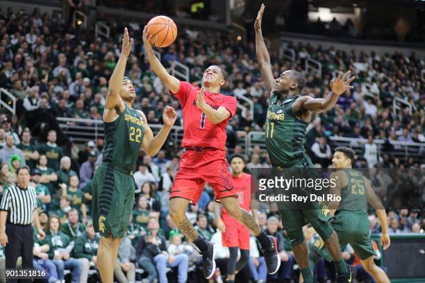 Anthony Cowan Jr. #1 of the Maryland Terrapins drives to the basket defended by Miles Bridges and Lourawls Nairn Jr. #11 of the Michigan State...