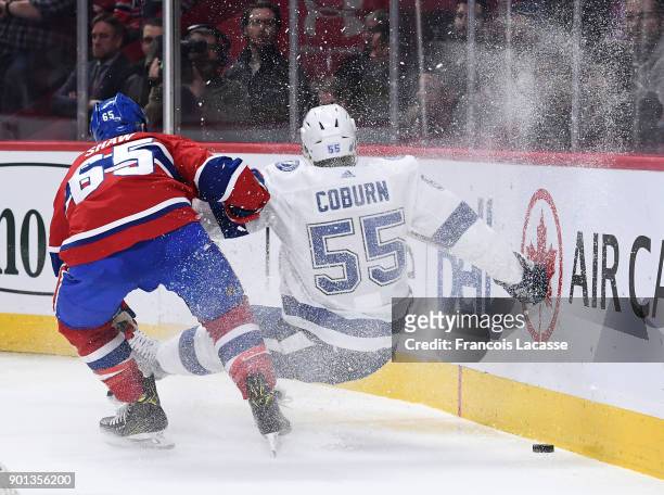 Andrew Shaw of the Montreal Canadiens checks Braydon Coburn of the Tampa Bay Lightning in the NHL game at the Bell Centre on January 4, 2018 in...