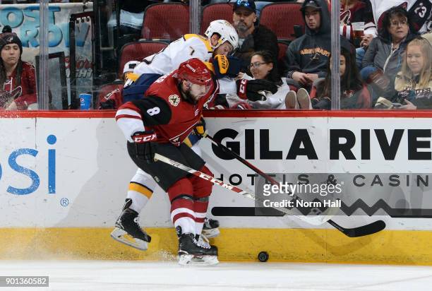 Tobias Rieder of the Arizona Coyotes checks Yannick Weber of the Nashville Predators into the boards during the second period at Gila River Arena on...