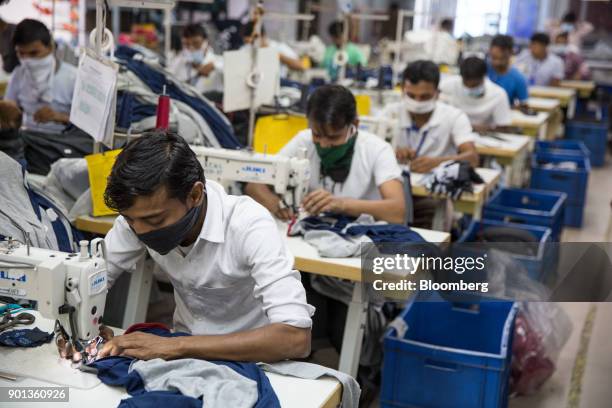 Employees wearing face mask operate sewing machines at a Rajlakshmi Cotton Mills Ltd. Garment factory in Kolkata, West Bengal, India, on Monday, Dec....