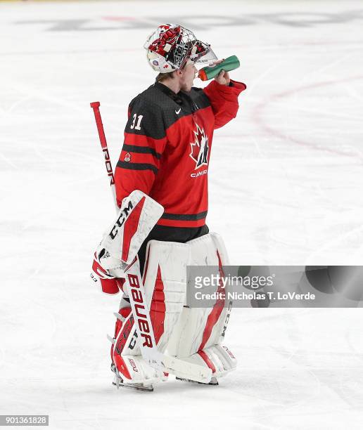 Carter Hart of Canada grabs a drink before heading to the bench for a timeout during the third period of play against the Czech Republic in the IIHF...