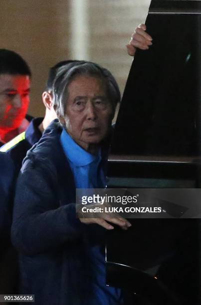 Peru's former President Alberto Fujimori boards a car after he was wheeled out of the Centenario Clinic in Lima on January 04 where he was...