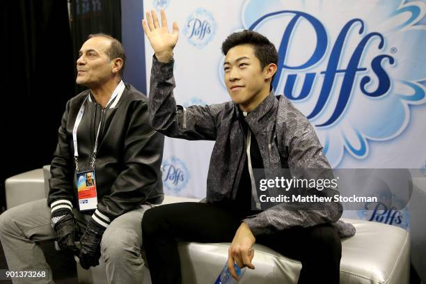 Nathan Chen waits for his score in the kiss and cry with his coach Rafael Arutunian after skating in the Men's Short Program during the 2018...