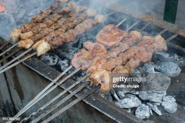 a charcoal barbecue is being used lamb skewers and lamb waists - schmorbraten stock-fotos und bilder