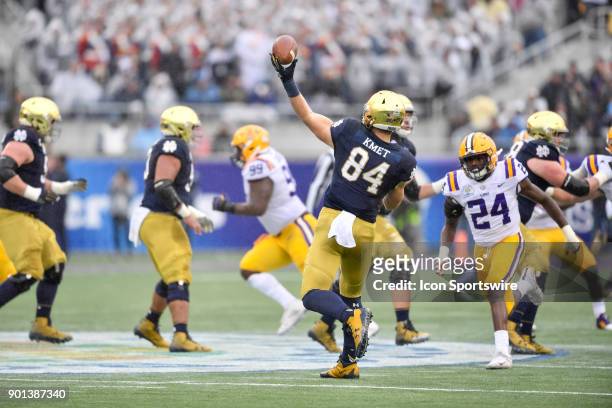 Notre Dame Fighting Irish tight end Cole Kmet throws a deep pass on a trick play while pressured by LSU Tigers linebacker Tyler Taylor during the...