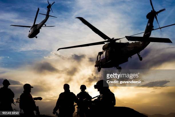 silhouetten von soldaten während der militärmission in der abenddämmerung - armed forces stock-fotos und bilder