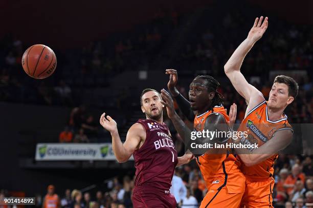 Cam Gliddon and Jerry Evans Jr. Of the Taipans block a shot from Adam Gibson of the Bullets during the round 13 NBL match between the Cairns Taipans...