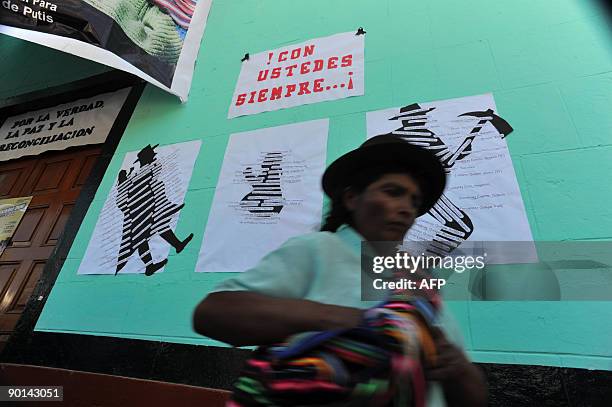 Woman passes by posters with names of victims as the remains of more than 90 people killed and dissapeared in Putis, Ayacucho ---600 km southeast of...