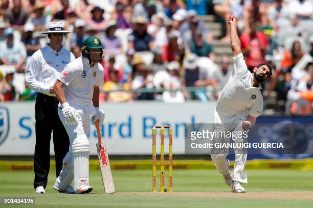 Indian bowler Mohammed Shami delivers a ball to South African batsman Faf du Plessis as South African batsman AB de Villiers looks on during day one...