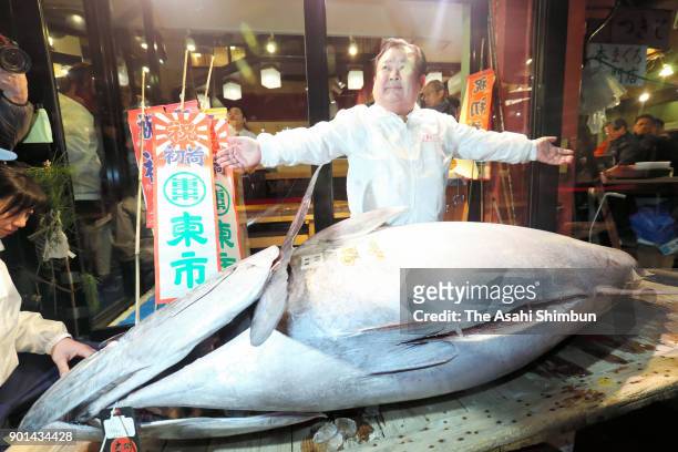 Kiyoshi Kimura, president of Kiyomura Corp., operator of the Sushizanmai restaurant chain, poses with the bluefin tuna after the year's first auction...