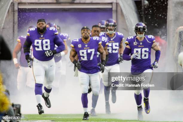 Linval Joseph, Everson Griffen and Brian Robison of the Minnesota Vikings run onto the field before the game against the Chicago Bears on December...