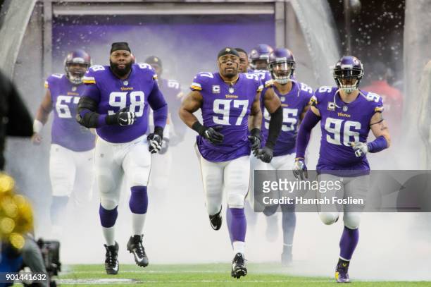Linval Joseph, Everson Griffen and Brian Robison of the Minnesota Vikings run onto the field before the game against the Chicago Bears on December...