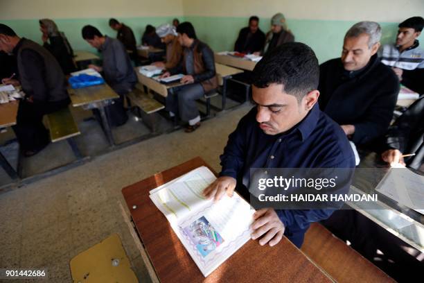 Iraqi men take part in an Iraqi government's literacy program for adults in the holy city of Najaf on January 5, 2018.