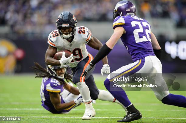 Tarik Cohen of the Chicago Bears carries the ball against Trae Waynes and Harrison Smith of the Minnesota Vikings during the game on December 31,...