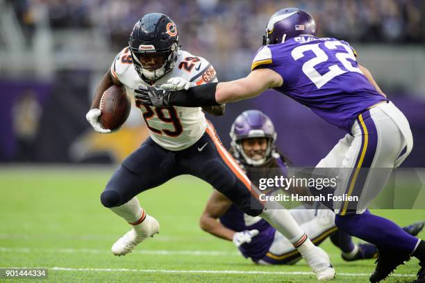 Tarik Cohen of the Chicago Bears carries the ball against Trae Waynes and Harrison Smith of the Minnesota Vikings during the game on December 31,...