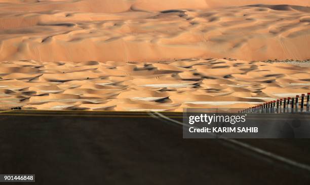 General view shows a road in the Liwa desert, some 250 kilometres west of the Gulf Emirate of Abu Dhabi, during the Liwa 2018 Moreeb Dune Festival on...