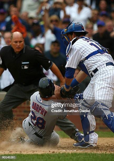 Daniel Murphy of the New York Mets is tagged out at home plate by catcher Geovany Soto of the Chicago Cubs in the eighth inning of their game at...