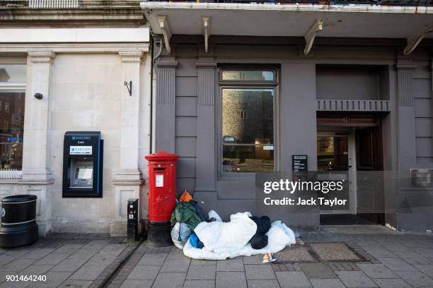 Person sleeps rough in front of a bank on January 5, 2018 in Windsor, England. British Prime Minister Theresa May has publicly challenged comments...