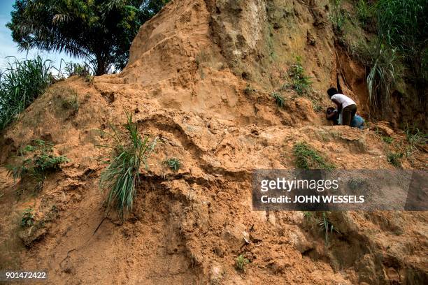 Women mourn the death of a family member following a landslide on January 5, 2018 in Kinshasa. Thirty-seven people died overnight when torrential...