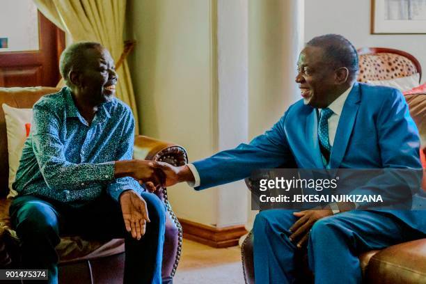 Zimbabwe's President Emmerson Mnangagwa shakes hands with the leader of the Movement for Democratic Change , the country's main opposition party,...