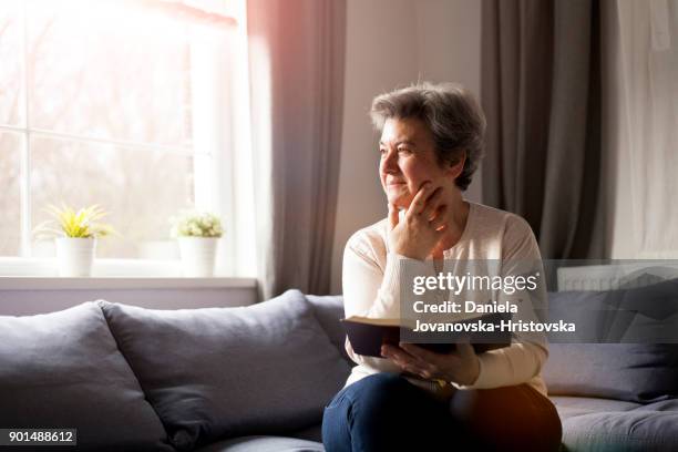 mujer senior con biblia - religious text fotografías e imágenes de stock