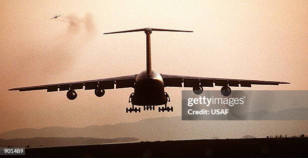 75th Airlift Squadron C-5B Galaxy aircraft is silhouetted by the sunset as it lands on base.