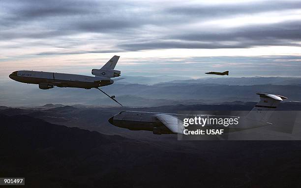 An air-to-air left side view of a C-5 Galaxy aircraft approaching a KC-10 Extender aircraft for refueling.