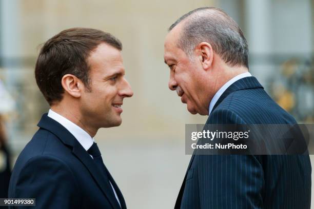 French President Emmanuel Macron welcomes his Turkish counterpart Recep Tayyip Erdogan upon his arrival for their meeting and luncheon on January 5,...