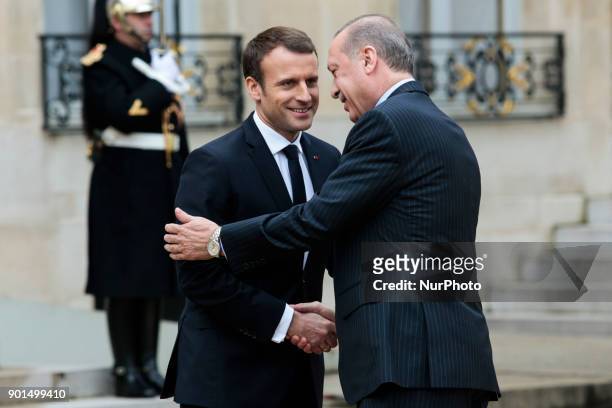 French President Emmanuel Macron welcomes his Turkish counterpart Recep Tayyip Erdogan upon his arrival for their meeting and luncheon on January 5,...