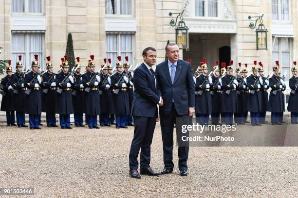 French President Emmanuel Macron welcomes his Turkish counterpart Recep Tayyip Erdogan upon his arrival for their meeting and luncheon on January 5,...