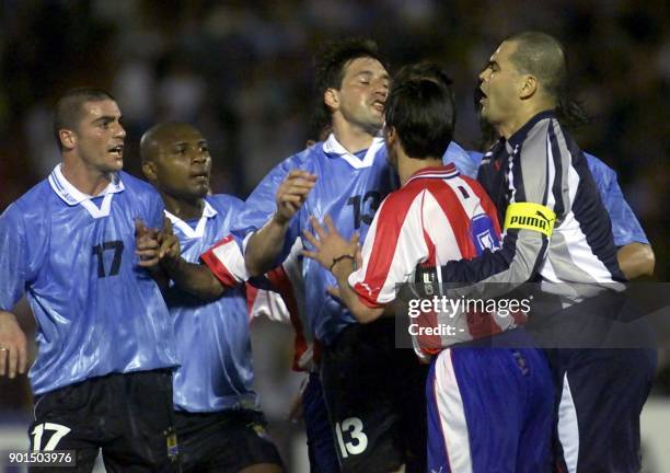 Uruguayan soccer players Walter Pandiani and Marcelo Zalayeta and Fabian O'Neil shout at Paraguayan goalkeeper Jose Chilavert during incidents that...