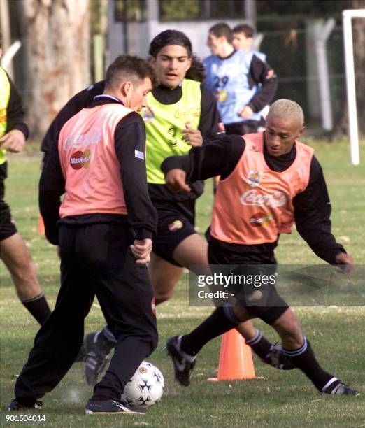 Dario Silva and Fabian O'neil guard the ball against Federico Magallanes during a practice of the Uruguayan soccer team 14 July, 2000 in Montevideo,...