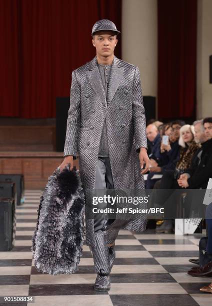 Model walks the runway wearing a design by Xu Bo at the LCFMA18 Menswear show during London Fashion Week Men's January 2018 at St John's, Smith...